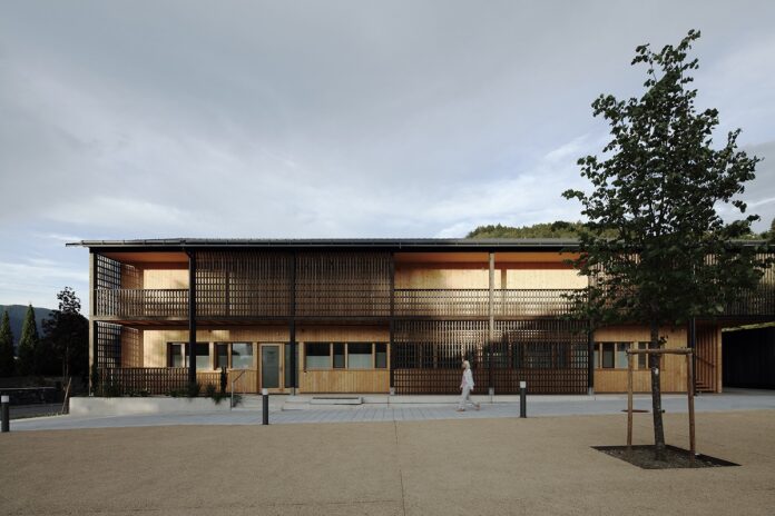 Neues Dorfzentrum Teufenbach Lendarchitektur and Scheiberlammer Architekten Fotos: Christian Brandstätter Auf dem Bild ist ein Gebäude aus Holz zu sehen. Es ist ein moderner Bau mit Balkon, und beleuchtet. Neues Dorfzentrum Teufenbach Lendarchitektur and Scheiberlammer Architekten