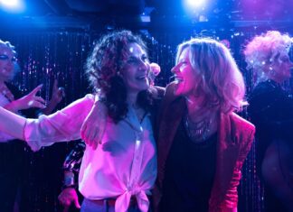 Loud & Proud: Austrian Queer Cinema / Kulturforum New York Das Bild zeigt zwei Frauen in herzlicher Umarmung, die einander tief in die Augen blicken. Ihre Kleidung und Mimik spiegeln Nähe, Humor und Spannung wider – eine Szene aus dem Film What a Feeling