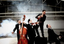 Jánoška Ensemble / Kulturforum Zagreb Das Bild zeigt das spielende Quartett in einer Halle und in schwarzen Smokings.