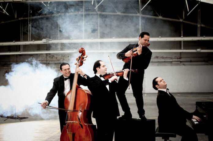 Bild: Julia Wesely Das Bild zeigt das spielende Quartett in einer Halle und in schwarzen Smokings.