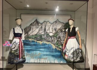 Hallstatt- Austrian’s Heart of Gold in Shanghai / Generalkonsulat Shanghai Das Bild zeigt die Ausstellungswerke von Sabine Linke Links und Rechts eine Puppe im Dirndl mit schöner handbemalter Schürze. In der Mitte im Hintergrund ein gemaltes Bild von Hallstatt,