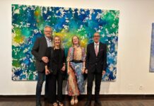 Ausstellung / Botschaft Brasilia Das Bild zeigt ein großformatiges abstraktes Kunstwerk in kräftigem Blau, Grün und Gelb und davor aufgestellt die Künstlerin Monika Kus-Picco mit Ehemann sowie Botschafter Dr. Stefan Scholz mit Ehefrau.