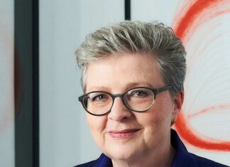 Hannah Rieger: Eine Stimme für Art Brut Auf dem Bild sieht man Hannah Rieger in Großaufnahme, sie trägt kurzes graues Haar und eine Brille und lächelt in die Kamera.