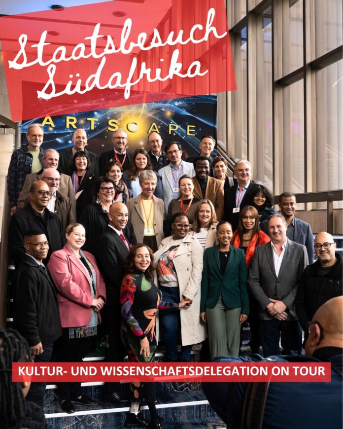 Das Bild zeigt die gesamte Kultur- und Wissenschaftsdelegation; abgebildet auf einer Stiege stehend mit der Leitung des Artscape Theatre Centres in Kapstadt: Übertitelt mit: „Staatsbesuch Südafrika“ und „Kultur und Wissenschaftsdelegation on Tour“.