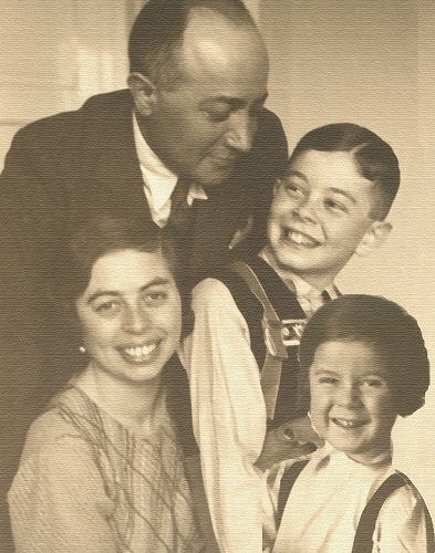 Bild: Museum der Jüdischen Kultur – Holocaust-Museum in Sereď Auf dem Schwarz Weiss Bild ist die vierköpfige Familie Munk zu sehen, Der Vater im schwarzen Anzug lächelt seinem Sohn zu, der Sohn in der Lederhose, die Mutter lächelt in die Kamera und das Mädchen mit kurzen braunen Haaren lacht fröhlich.
