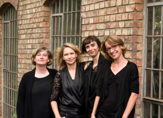 airborne extended / Kulturforum Washington Das Bild zeigt vier junge Frauen in Schwarz gekleidet vor einer Backsteinmauer.