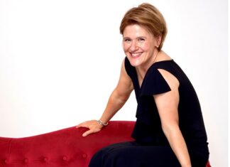 Anthologie Ukrainischer Musik / Kulturforum Berlin Das Bild zeigt Pianistin Senka Brankovic, die auf der Lehne einer roten Couch sitzt. Sie trägt ein schwarzes Kleid und lächelt in die Kamera.