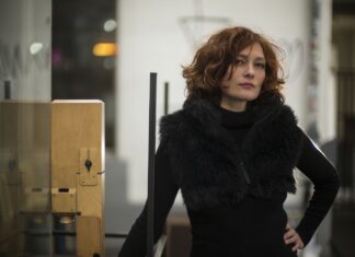 Eva REITER «WASTORIES»Weltpremiere / Kulturforum Paris Eva Reiter steht im schwarzen Wintermantel mit Pelz