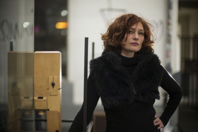 Eva Reiter steht im schwarzen Wintermantel mit Pelz
