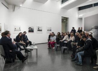 Buchpräsentation „Motherland hears, Motherland knows“ / Fotohof Salzburg Das Bild zeigt vorne die Künstlerin, Herrn Staatssekretär Schellhorn, Frau Rabl-Stadler und noch einen Künstler, die miteinander sprechen. Davor das interessierte Publikum, sitzend, ca 30 Personen, an den Wänden die Fotografien.