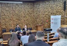 Lesung von Theresia Töglhofer / Botschaft Pristina Das Bild zeigt die Autorin und den Moderator von der Perspektive des Publikums im Saal der Nationalbibliothek .