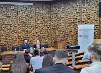 Lesung von Theresia Töglhofer / Botschaft Pristina Das Bild zeigt die Autorin und den Moderator von der Perspektive des Publikums im Saal der Nationalbibliothek .
