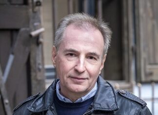 Alois Hotschnig: „Der Silberfuchs meiner Mutter” Das Bild zeigt ein Portrait von Alois Hotschnig. Er trägt eine schwarze Lederjacke, darunter einen Wollpullover und ein Hemd, seine Haare sind grau meliert, er lächelt in die Kamera.