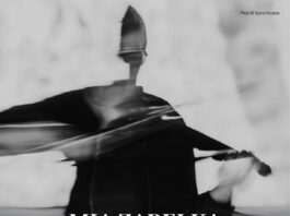 Mia Zabelka / Botschaft Oslo Das Bild ist ein schwarz-weißes Konzertplakat im Hochformat. Im Hintergrund ist eine abstrakte, leicht verschwommene Fotografie einer Person zu sehen, die eine Violine spielt. Die Bewegung des Arms und des Bogens ist verwischt, wodurch ein Eindruck von Dynamik, Klang und körperlicher Präsenz entsteht. Das Gesicht ist nicht klar erkennbar, was dem Bild einen anonymen, künstlerischen Charakter verleiht. Die Gesamtwirkung ist expressiv und atmosphärisch. Die Farbgestaltung ist reduziert auf Schwarz-, Grau- und Weißtöne. Der untere Bereich des Plakats ist dunkler gehalten, um den hell gesetzten Text gut lesbar hervorzuheben.