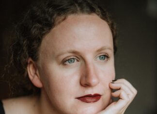 Siljarosa Schletterer: Zwei Talente einer Frau / Podcast wissensArt Auf dem Bild sieht man die Autorin in Nahaufnahme, sie blickt verträumt in die Ferne und stützt den Kopf auf die Hand.