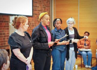 Workshop und Vortrag / Kulturforum Pretoria Auf dem Bild sieht man vier Personen auf einer Bühne, die miteinander etwas vortragen.