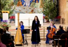 Weihnachtskonzert / Kulturforum Sarajewo Das Bild zeigt drei Musikerinnen beim Konzert in einer Kirche - eine Harfenistin links, eine Sängerin in der Mitte und eine Cellistin rechts.