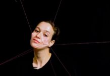 Österreich bei der Hybrid Art Fair / Kulturforum Madrid 1) Das Bild zeigt die Künstlerin, der Haut im Gesicht an rote Fäden geknüpft ist, die diese in mehrere Richtungen ziehen und somit das Gesicht entstellen.