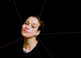 Österreich bei der Hybrid Art Fair / Kulturforum Madrid 1) Das Bild zeigt die Künstlerin, der Haut im Gesicht an rote Fäden geknüpft ist, die diese in mehrere Richtungen ziehen und somit das Gesicht entstellen.