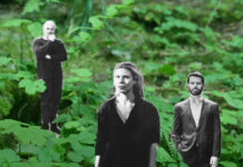 Da kommt noch wer / Botschaft Oslo In einem dichten, grünen Wald mit Farnen und Unterholz stehen drei schwarz-weiße, ausgeschnittene Personenfiguren, die wie in die Natur hineingestellt wirken. Im Vordergrund befindet sich eine Frau mit schulterlangem Haar und dunkler Kleidung, die geradeaus blickt. Etwas dahinter stehen zwei Männer: links eine Person mit nachdenklicher Haltung und angewinkeltem Arm, rechts ein Mann in Anzugjacke mit offenem Hemd, der frontal nach vorn schaut. Der starke Kontrast zwischen den grauen Figuren und der lebendigen, grünen Waldumgebung erzeugt einen collageartigen, surrealen Eindruck.