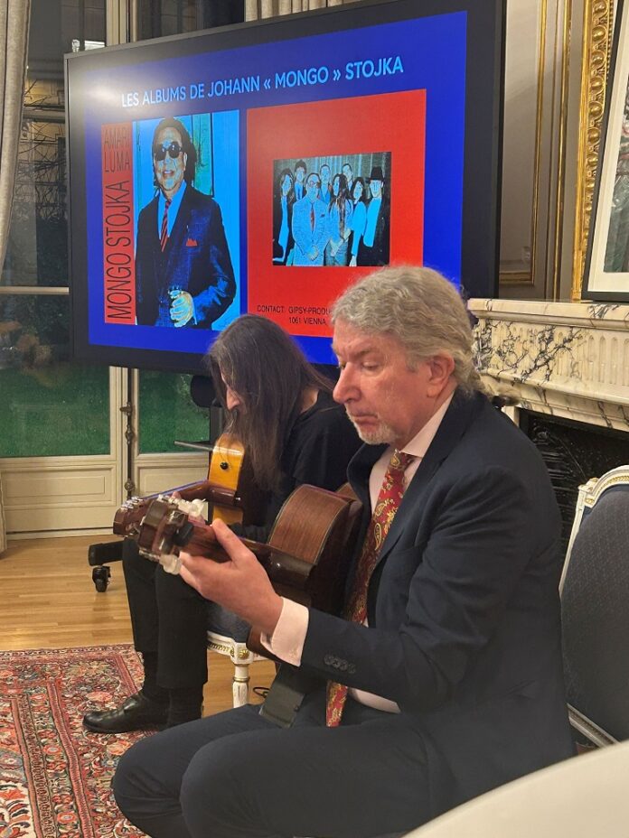 Es ist Harry Stojka auf der Gitarre spielend zu sehen