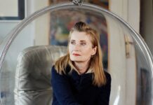 Internationale Jelinek Tage / Veranstaltungen Man sieht Elfriede Jelinek, sie sitzt in einem durchsichtigen Schwingsessel und blickt in die Ferne. elfriede jelinek in ihrem haus 1140 wien bubble chair von aarnio eero