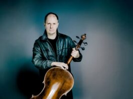 Giovanni Gnocchi / Kulturforum Mexiko Das Bild zeigt den Musiker Giovanni Gnocchi mit seinem Cello vor einem blauen Hintergrund.