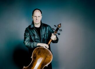 Giovanni Gnocchi / Kulturforum Mexiko Das Bild zeigt den Musiker Giovanni Gnocchi mit seinem Cello vor einem blauen Hintergrund.