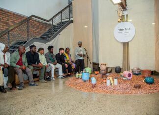 Artists-in-Residence / Kapstadt Das Bild zeigt eine Gruppe Menschen um Kunstgegenstände versammelt