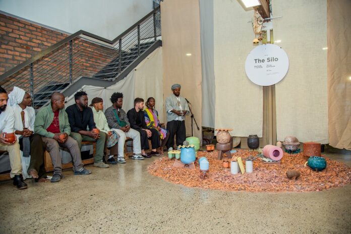 Das Bild zeigt eine Gruppe Menschen um Kunstgegenstände versammelt