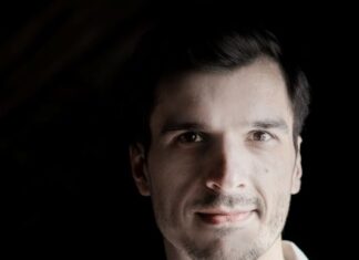 Christoph Urbanetz / Kulturforum Mexiko Das Bild zeigt den Musiker Christoph Urbanetz mit seiner Gambe vor einem schwarzen Hintergrund.