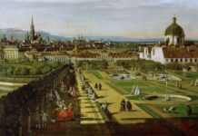 Austria in the UNESCO Mission / Kulturforum New York Das Gemälde View of Vienna from the Belvedere von Bernardo Bellotto zeigt einen weiten Blick über Wien im 18. Jahrhundert, gesehen vom Belvedere aus. Im Vordergrund erstreckt sich ein streng symmetrisch angelegter Barockgarten mit geometrischen Rasenflächen, Kieswegen und mehreren Brunnenbecken. Elegant gekleidete Menschen flanieren, stehen in kleinen Gruppen zusammen oder sitzen entlang einer von Bäumen beschatteten Allee. Einige Figuren wirken beschäftigt, andere entspannen oder unterhalten sich. Rechts dominiert ein großes Gebäude mit heller Fassade und einer markanten Kuppel, während sich links der Garten entlang einer Balustrade und eines Wasserbeckens fortsetzt. Im Mittelgrund liegen weitere Palastbauten und Gartenanlagen. Dahinter öffnet sich die Stadt Wien mit dicht stehenden Häusern und zahlreichen Kirchtürmen. Besonders auffällig ist ein sehr hoher, spitzer Turm, der die Skyline überragt. Im Hintergrund sind sanfte Hügel und ein heller Himmel mit zarten Farbverläufen zu sehen, der dem Bild eine ruhige, weite Atmosphäre verleiht.