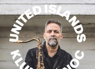 United Islands / Kulturforum Prag Das Bild zeigt den Musiker Ulrich Drechsler mit dem Saxofon, über sein Foto ist die weiße Inschrift „United Islands Klubová noc, Ulrich Drechsler & Azure Trio, 29.4. 19:30, Chodovská tvrz“ zu sehen