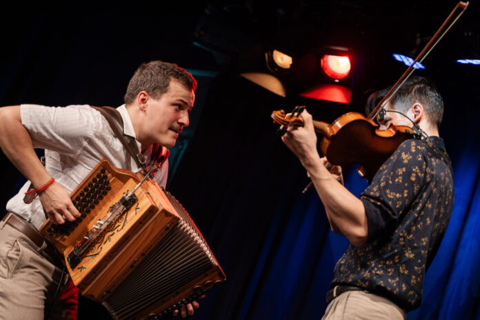 Das Bild zeigt Jakob Steinkellner (links) an der Harmonika und Tomáš Novak (rechts) an der Geige wie sie gemeinsam musizieren.