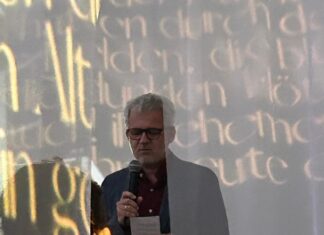 EUNIC – Welttag der Poesie / Botschaft Algier Das Bild zeigt den von Schleiern umgebenen Botschafter beim Lesen eines Trakl-Gedichts