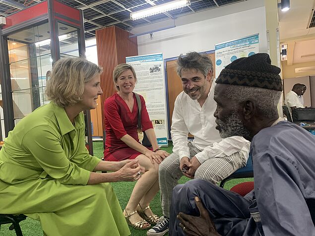 Das Bild zeigt Dr. Gabriele Slezak (Institut für Afrika Wissenschaften, Universität Wien) im Gespräch mit Paul Kaiser (Enkel Walter Pichls) und Aliou Dione Cissé (Vertreter der KOLAMKING SAAFI- Association der Saafen).