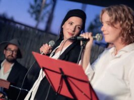 Playbackdolls /Eva Schörkhuber / Botschaft Pristina Das Bild zeigt zwei Performerinnen mit Mikrofon und einen Klavierspieler im Hintergrund