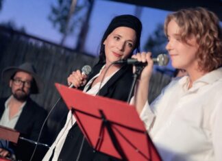 Playbackdolls /Eva Schörkhuber / Botschaft Pristina Das Bild zeigt zwei Performerinnen mit Mikrofon und einen Klavierspieler im Hintergrund