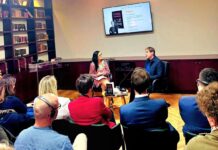 Daniel Kehlmann in Albanien/ Botschaft Tirana Das Bild zeigt eine Szene der Veranstaltungen aus der Sicht eines Teilnehmenden. Im Vordergrund das Publikum Auf Stühlen sitzend, im Hintergrund die Bühne.