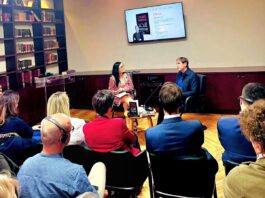 Daniel Kehlmann in Albanien/ Botschaft Tirana Das Bild zeigt eine Szene der Veranstaltungen aus der Sicht eines Teilnehmenden. Im Vordergrund das Publikum Auf Stühlen sitzend, im Hintergrund die Bühne.