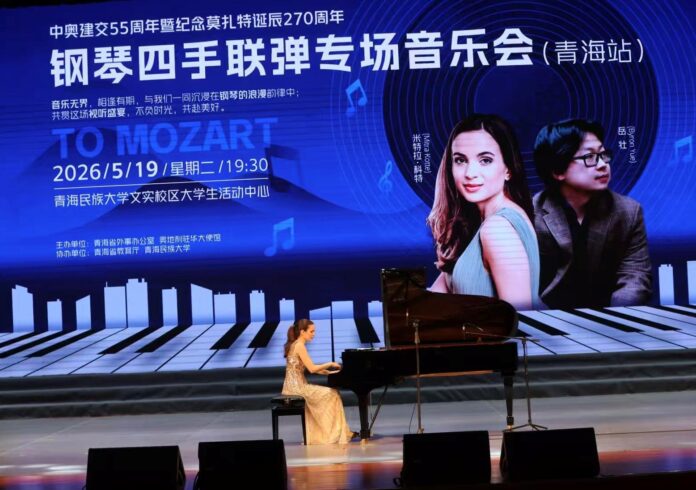 Bild: Kulturforum Peking Das Bild zeigt eine Pianistin bei einem Konzert auf einer Bühne in China. Im Hintergrund ist eine große Projektion mit chinesischer Beschriftung zu sehen, die auf ein Klavierkonzert anlässlich des 55-jährigen Jubiläums der diplomatischen Beziehungen zwischen Österreich und China sowie des 270. Geburtstags von Mozart hinweist.