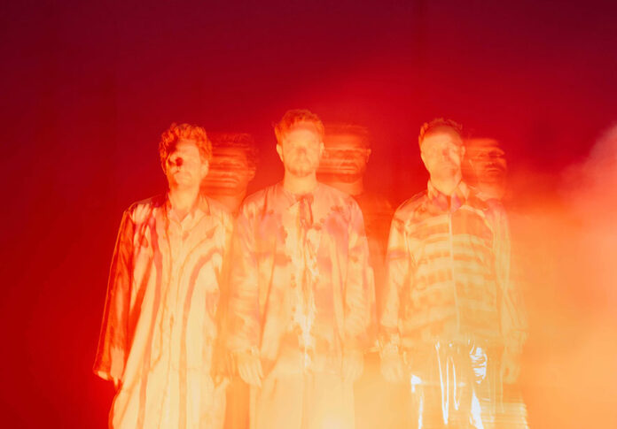 Das abstrakte orange-fluoreszierende Bild zeigt die Musik-Formation Elektro Guzzi.
