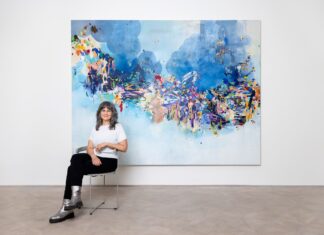 Käthe Schönle / Kulturforum Berlin Die Künstlerin Käthe Schönle sitzt vor einem ihrer abstrakten Kunstwerke.
