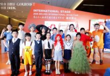 EUNIC Literaturtag / Kulturforum Peking Chinesische Kinder in bunten Kostümen auf der Bühne der Beijing International Book Fair, im Hintergrund die Aufschrift „International Stage".