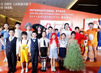 EUNIC Literaturtag / Kulturforum Peking Chinesische Kinder in bunten Kostümen auf der Bühne der Beijing International Book Fair, im Hintergrund die Aufschrift „International Stage".