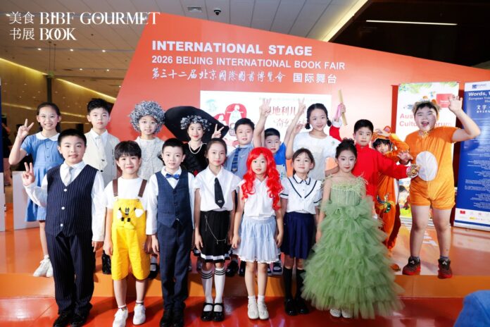 Chinesische Kinder in bunten Kostümen auf der Bühne der Beijing International Book Fair, im Hintergrund die Aufschrift „International Stage