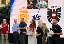 Fußball Public Viewing / Botschaft Algier Gruppe von Menschen vor einem LED-Bildschirm mit den Logos der österreichischen und argentinischen Nationalmannschaft.