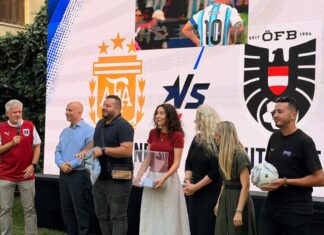 Fußball Public Viewing / Botschaft Algier Gruppe von Menschen vor einem LED-Bildschirm mit den Logos der österreichischen und argentinischen Nationalmannschaft.