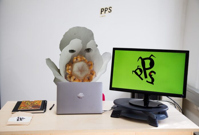 Bild: Lena Violetta Leitner, PPS 2026; adaptiertes Bildmaterial: © Achim Lammerts/Wikimedia Commons, © Walter Siegmund Collage-Werk mit einem Schreibtisch, Computer und Laptop im Vordergrund; dahinter eine fantasievolle Unterwasserkreatur.
