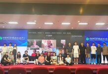 Bergrettung im Austausch / Kulturforum Peking Teilnehmende im Hörsaal des RCEES-CAS beim Gruppenfoto; auf der Leinwand im Hintergrund per Video zugeschaltete Expertinnen und Experten.